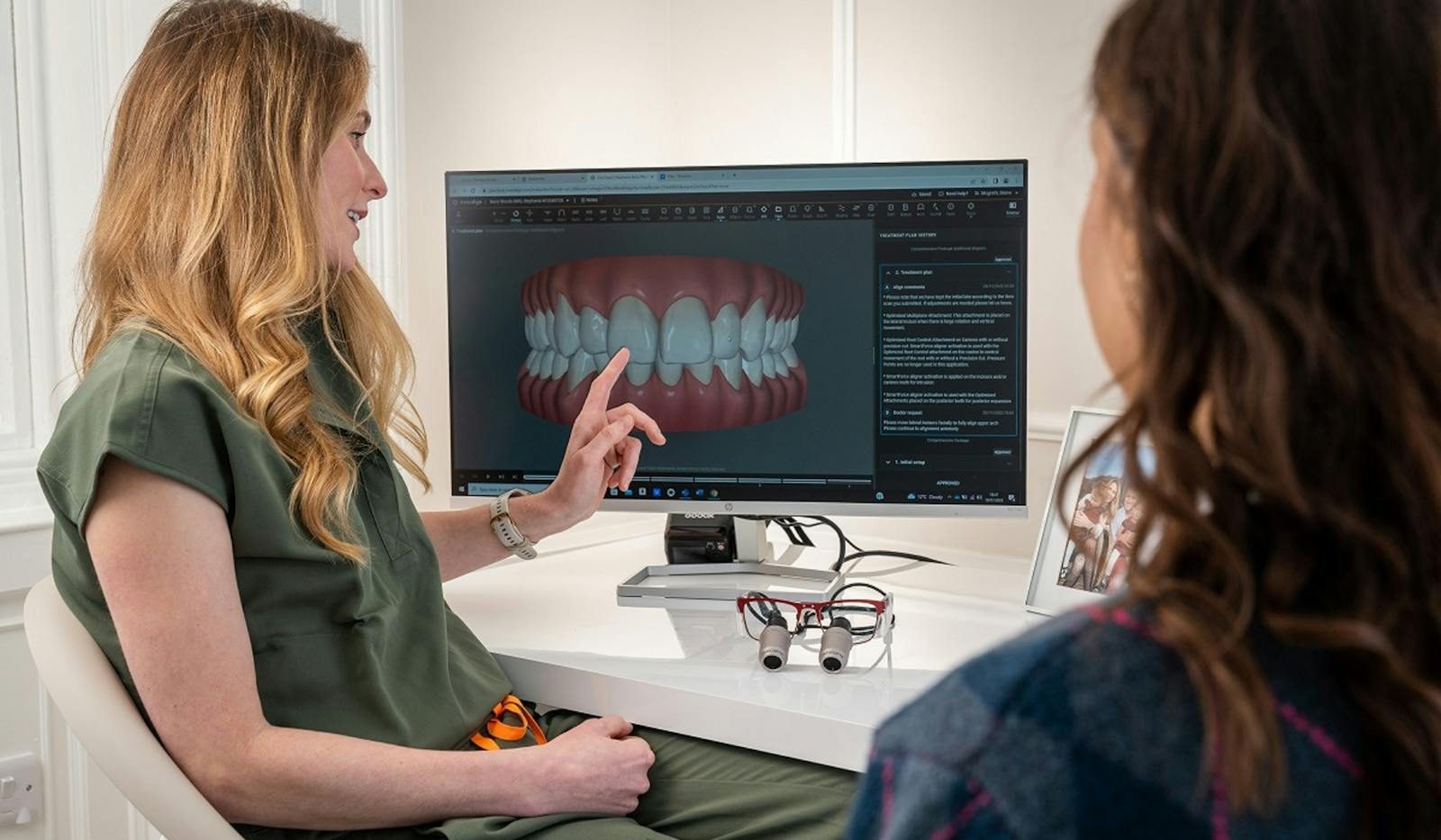 A dentist explains a 3D dental model to a patient during a consultation in Edinburgh.
